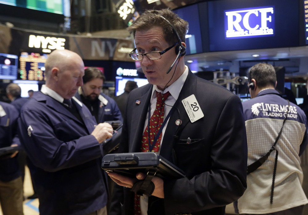 Trader Christopher Forbes, center, works on the floor of the New York Stock Exchange on Wednesday. The Standard & Poor index closed at a record high Thursday.