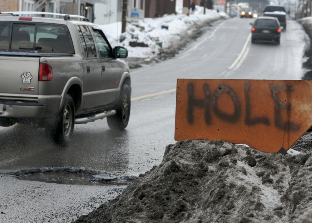 A sign warns motorists of a pothole in Pottsville, Pa. A report estimates that “unacceptably rough” roads cost the average urban driver $377 a year in repairs.