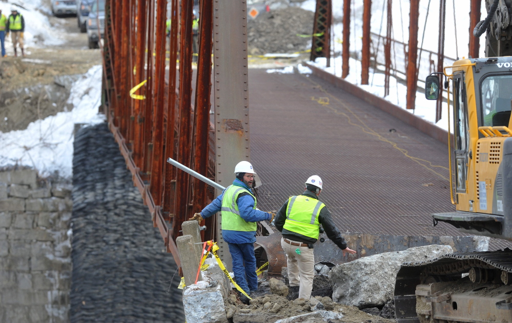 STANDING BY: Crews stand by as an excavator jackhammers the New Sharon bridge on Thursday.