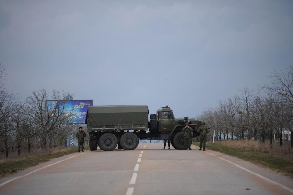 Russian troops block the road to the military airport at the Black Sea port of Sevastopol in Crimea, Ukraine, Friday. Heightened security is evident with Russian military around Sevastopol, the location for Russia military bases.