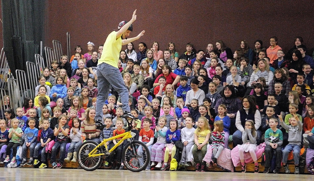 LIFE TRICKS: World Champion Bicycle Stunt Rider, Motivational Speaker and Author Chris Poulos does a trick as he talks to Cottrell School students in the Foster Memorial Gym at Monmouth Academy about bullying and other topics on Friday.
