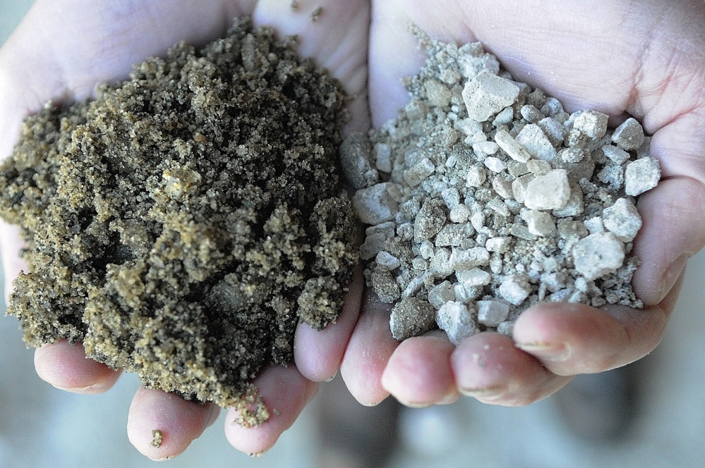 SHORT SUPPLY: Augusta Public Works director Lesley Jones holds up the new blend of 75 percent sand/25 percent salt, on left, and the old 75 percent salt mixture that they’d used previously. The city is changing the blend to stretch its salt supply.