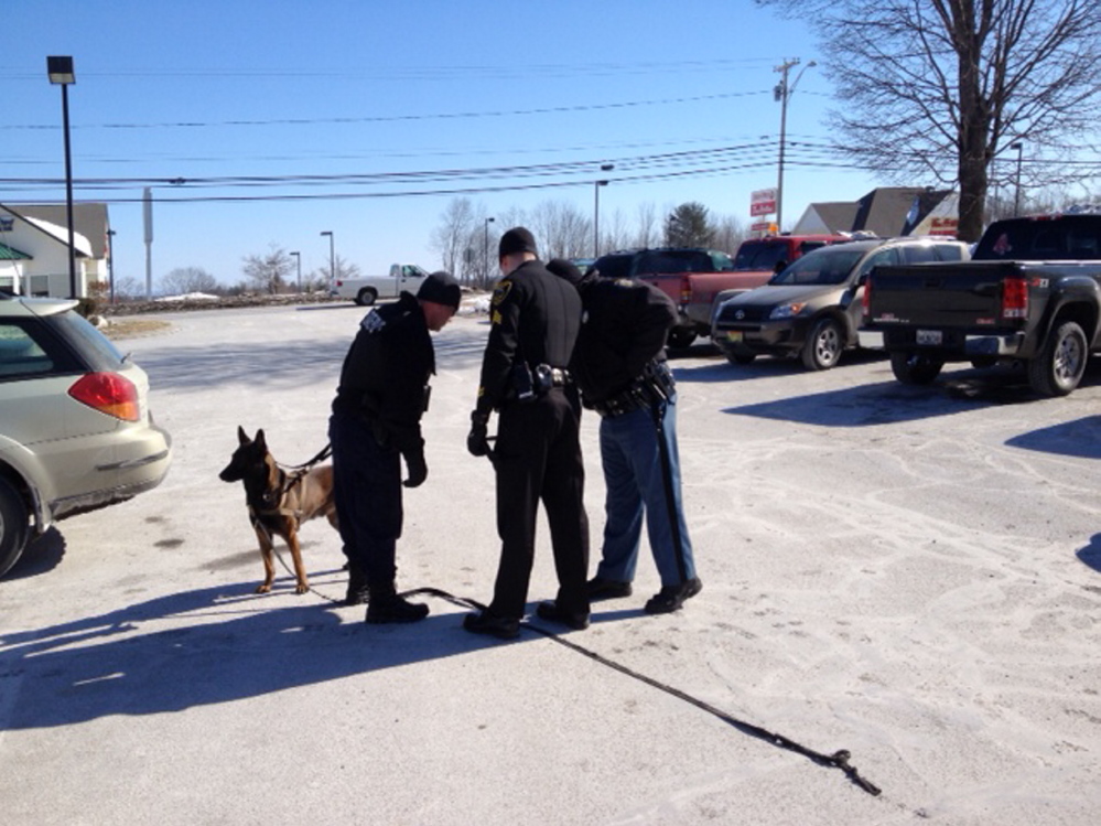search: Officers with a police dog, Foster, in the McDonald’s parking lot off upper Main Street Friday morning during the search for the robber of the nearby Bangor Savings Bank.