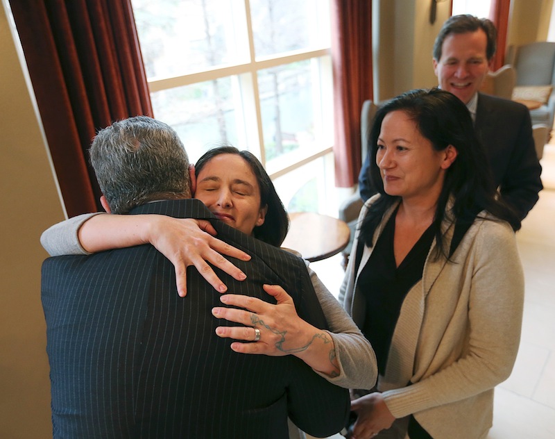 Nicole Dimetman hugs attorney Barry Chasnoff as her partner, Cleopatra De Leon, waits to greet him before a news conference in San Antonio on Wednesday, after U.S. Federal Judge Orlando Garcia declared a same-sex marriage ban in deeply conservative Texas unconstitutional.