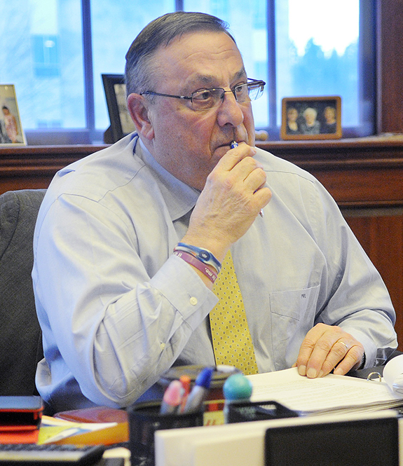 Gov. Paul LePage listens to an aide discuss a revision to his third State of the State address Monday during a meeting to compose the speech in the governor's office in Augusta.