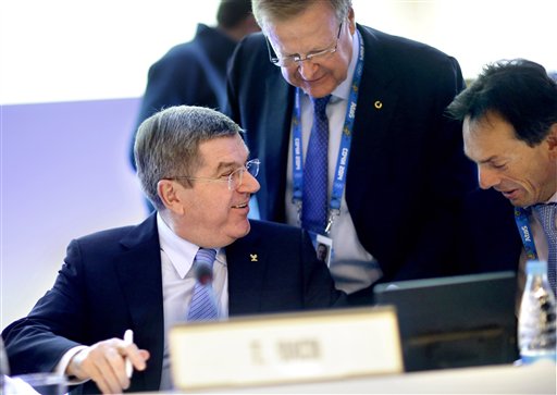 International Olympic Committee President Thomas Bach, left, talks with Director General Christophe De Kepper, right, and executive board member John Coates, prior to opening the IOC's general assembly at the 2014 Winter Olympics, Wednesday, Feb. 5, 2014, in Sochi, Russia. (AP Photo/David Goldman)