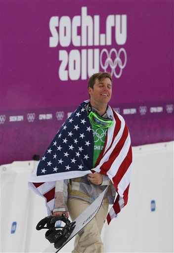 Bronze medalist Alex Deibold of the United States walks to a flower ceremony after the men's snowboard cross final at the Rosa Khutor Extreme Park, at the 2014 Winter Olympics, Tuesday, Feb. 18, 2014, in Krasnaya Polyana, Russia.