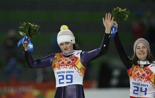 Germany's Carina Vogt celebrates winning the gold as France's bronze medal winner Coline Mattel looks on during the women's normal hill ski jumping final at the 2014 Winter Olympics, Tuesday, Feb. 11, 2014, in Krasnaya Polyana, Russia.