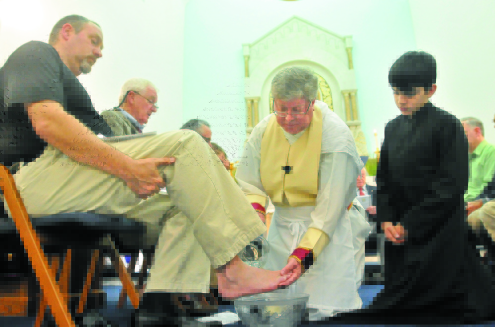 Priest: The Rev. Larry Jensen, center, washes the feet of parishioner David Lee, left, in 2013 as server Ben Hodgkin, right, watches the Holy Thursday ritual at St. Joseph Maronite Church in Waterville.