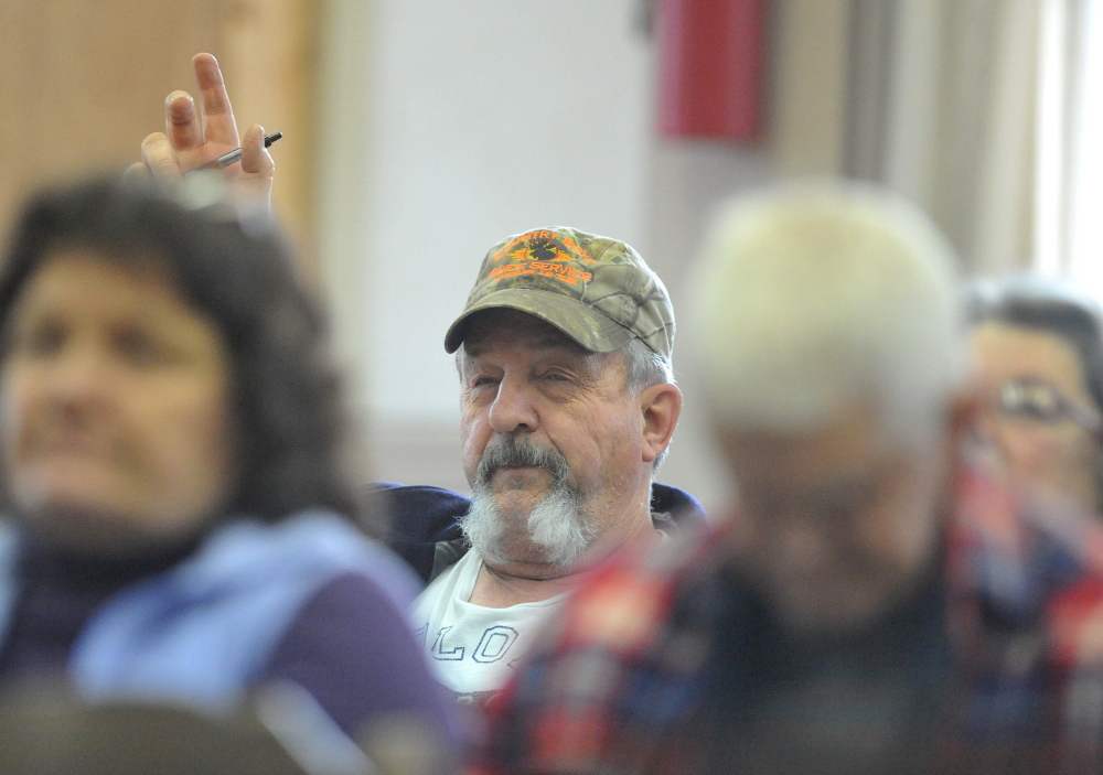 Residents Ask questions: Carroll Gould, raises his hand to ask a question during the annual Town Meeting at the Cornville Town Hall on Saturday.