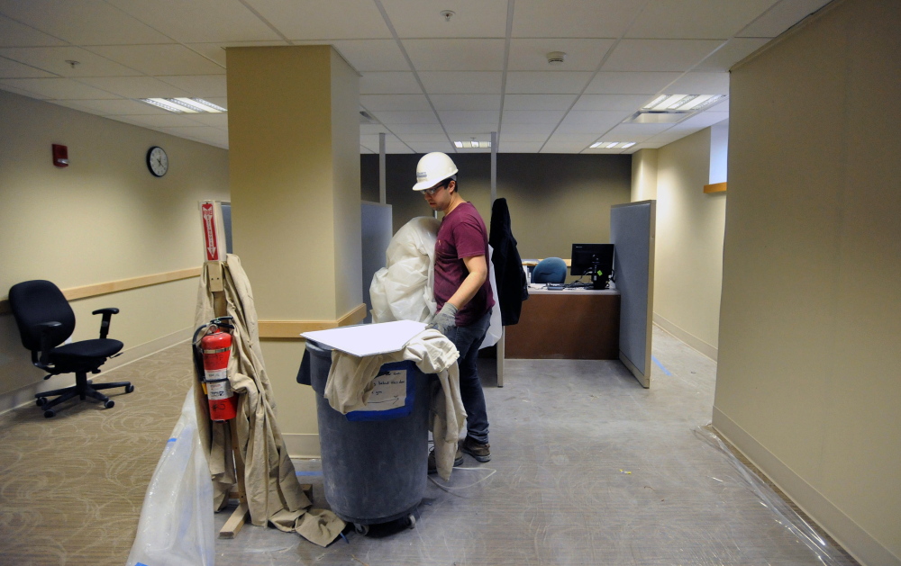 HOSPITAL WORK: Nate DeLeon, a laborer with JF Scott Construction, clears a portion of the newly renovated patient check-in office at Thayer Center for Health in Waterville on Feb. 21, 2014. The hospital is undergoing a $16 million renovation to be completed by Oct. 1, 2014.