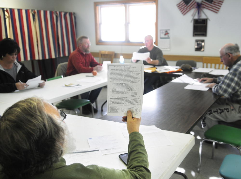 PARTY CAUCUS: James Hynson inspects a document Sunday during the Democratic Party caucus in Pittston. Democrats met across the state to elect officers and prepare for the fall election cycle.