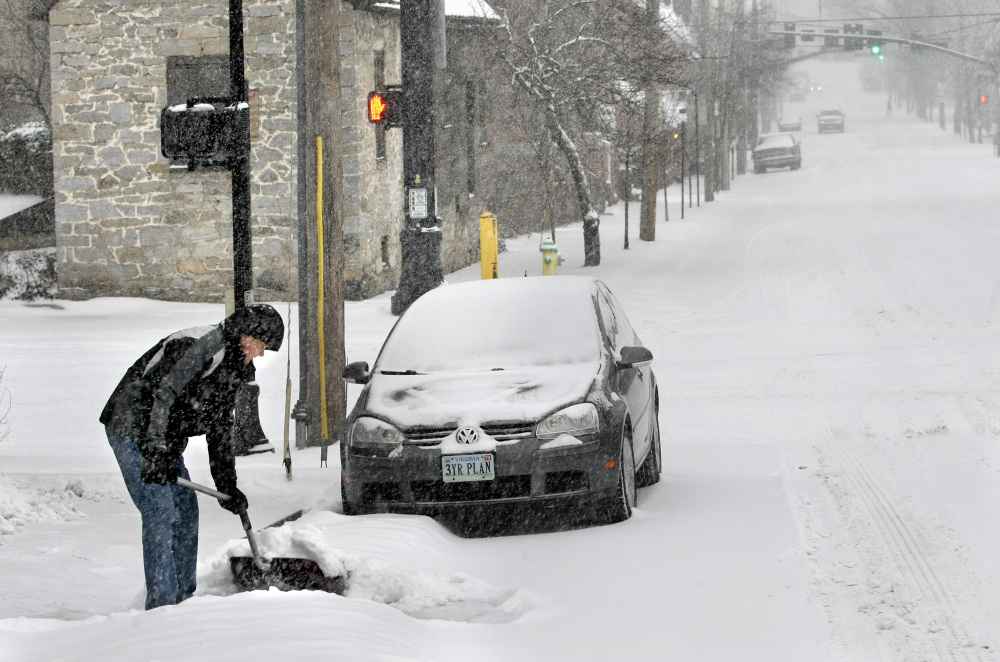 Tom Stark shovels snow from the sidewalk and driveway on Monday in Winchester, Va.