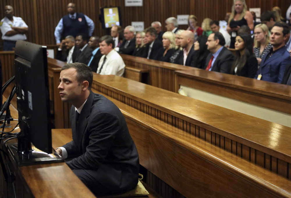 Oscar Pistorius sits in the dock prior to the start of his trial at the high court in Pretoria, South Africa, Monday. Pistorius denies murder and says he killed his girlfriend by mistake when he fired four times through a bathroom door thinking there was a dangerous nighttime intruder on the other side.