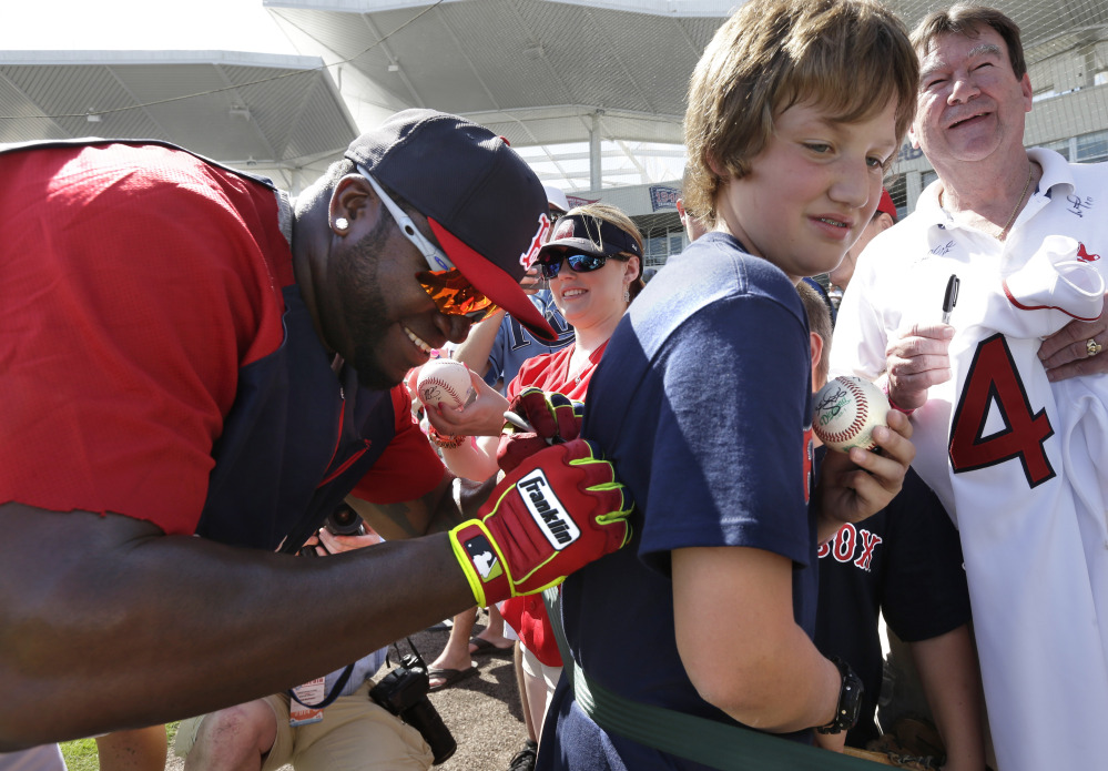 HAPPY FANS: Boston Red Sox designated hitter David Ortiz, left, signs an autograph on a shirt for Kobe Kellar of Orange Park, Fla. on Tuesday before an exhibition game against the Tampa Bay Rays. The Rays won 8-0 over the Red Sox.