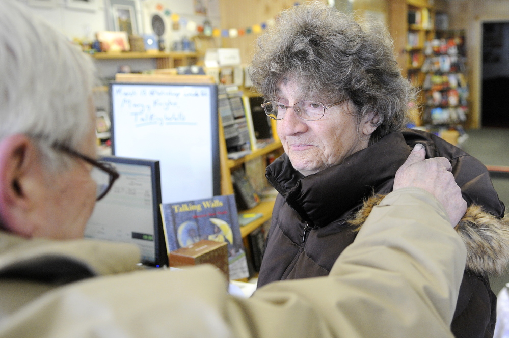 STREET PREACHER: The Rev. James Gill blesses Madeleine Roy, of Wayne, on Wednesday after smudging ashes on her forehead at Apple Valley Books in Winthrop. Gill applied the ashes, a Christian symbol of repentance before God, on Main Street as an extension of services at his Winthrop church.