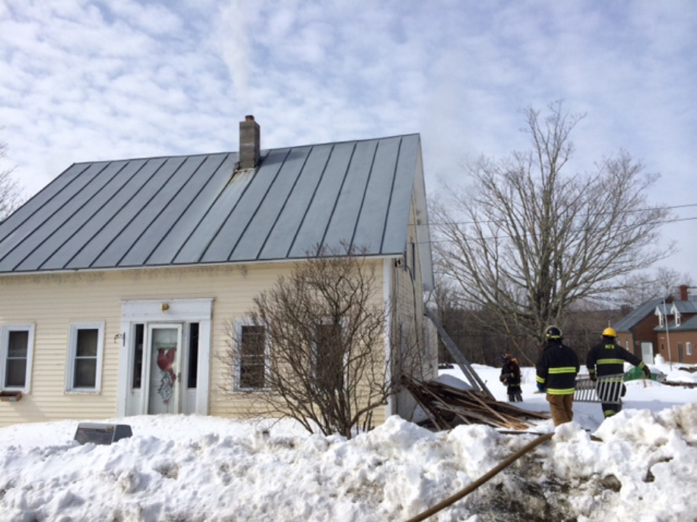HOUSE DAMAGED: Firefighters work at the scene of a fire Wednesday morning at 17 School St. in Athens.