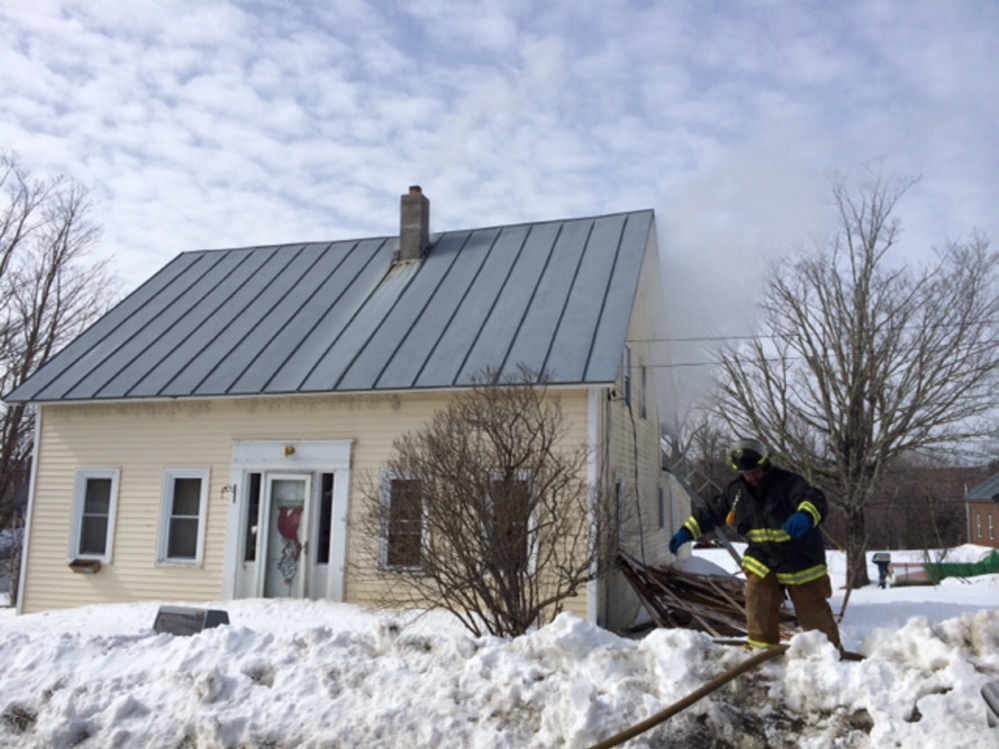 HOUSE DAMAGED: A firefighter works at the scene of a fire Wednesday morning at 17 School St. in Athens.