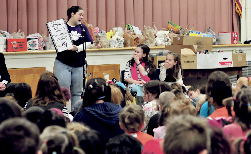 EARLY DISTINCTION: George J. Mitchell School students Gabbie St. Peter, left, and Alice Willette react happily Wednesday after school PTO President Jennifer Johnson announced that the school food pantry has been named Purple Panther Pantry in recognition of the girls’ efforts.