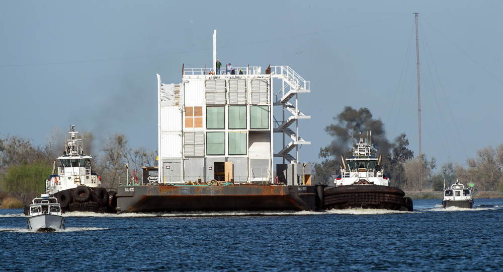 The Google mystery barge is guided through a channel on its way to the Port of Stockton in California on Thursday. The Internet company was ordered to move it out of San Francisco because it lacked the proper construction permits. A second mystery barge, berthed in Portland Harbor, doesn’t have any permit issues.
