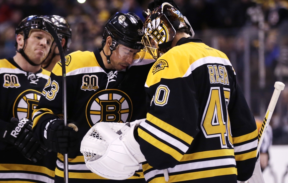 Boston Bruins goalie Tuukka Rask (40) bumps foreheads with teammate Chris Kelly after the Bruins defeated the Washington Capitals 3-0 during an NHL hockey game, Thursday, March 6, 2014, in Boston. At left is Bruins right wing Shawn Thornton.