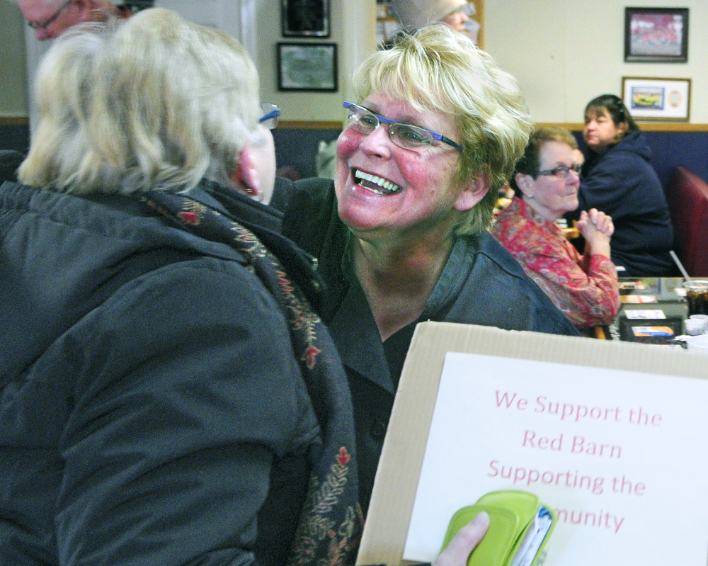 RAISING MONEY: REd Barn Owner Laura Benedict, right, hugs Carol Foreman, of South China, in November after she brought a sign supporting The Red Barn after the state attorney general notified the restaurant that it was violating state law. A bill heard Thursday would make it easier for small businesses to legally conduct fundraisers for charities.