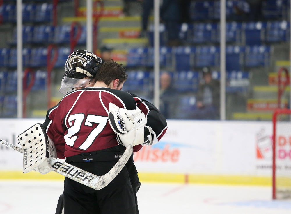 Justin Broy of Gorham embraces teammate Jared Wood after they lost 6-1 to Messalonskee in the Class B boys’ hockey state championship game Saturday at the Colisee in Lewiston.
