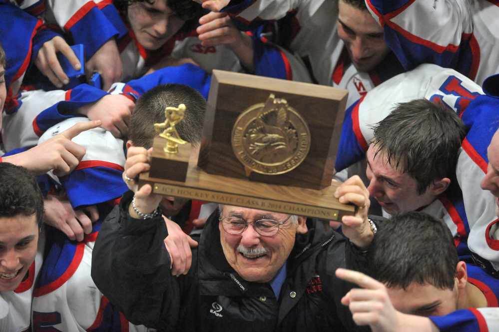 Staff photo by Michael G. Seamans The Messalonskee High School hockey team celebrates their State Championship with assistant coach Harvey "Lee" Bureau, after defeating Gorham High School 6-1 in the Class B state championship game at the Androscoggin Bank Colisee in Lewiston on Saturday.