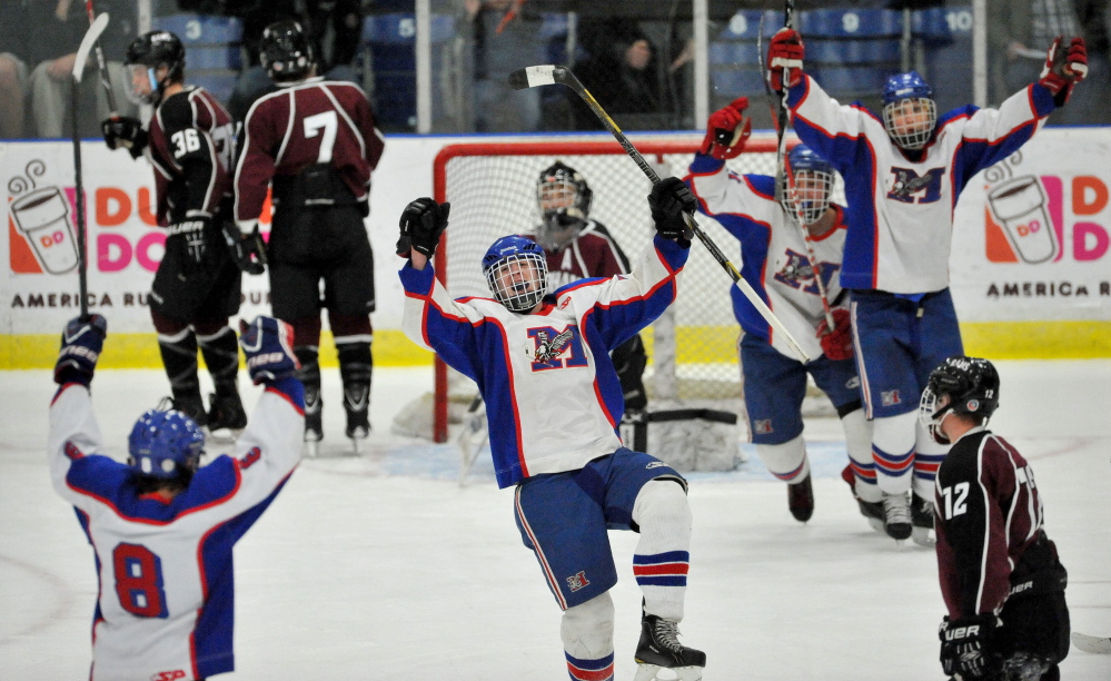 IT’S GOOD: Messalonskee High School’s Dan Condon, center, celebrates a goal in the first period of the Class B state championship game Saturday at the Androscoggin Bank Colisee in Lewiston. Messalonskee defeated Gorham 6-1.