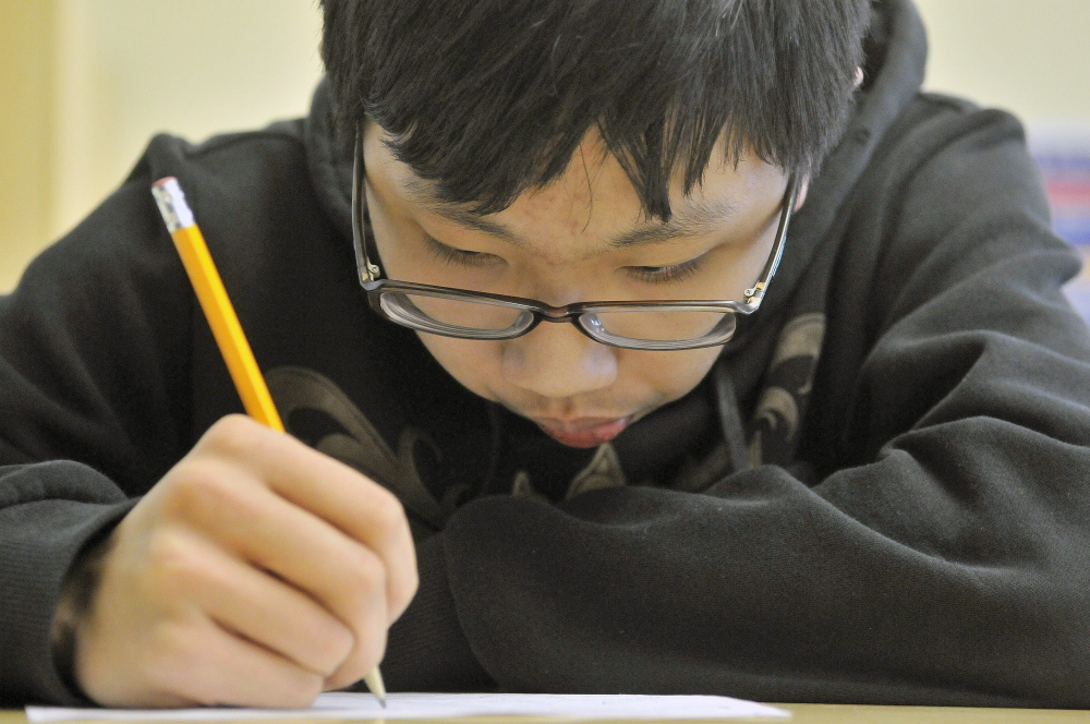 Calculating: Eric Lu, 15, a sophomore at Waterville Senior High School, works through a mathematics problem Wednesday during Waterville Math Team practice at Waterville Senior High School.