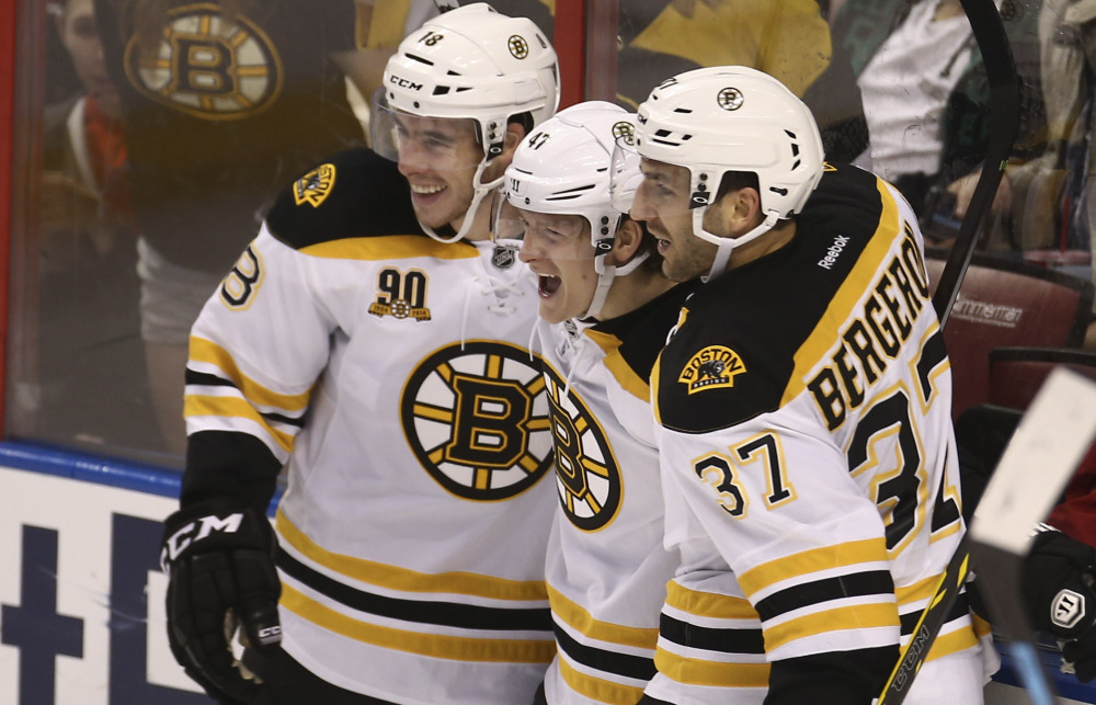 Bruins Reilly Smith, left, and Patrice Bergeron, right, celebrate with Torey Krug Sunday after Krug scored the go-ahead goal in the third period of Boston’s 5-2 win over Florida.