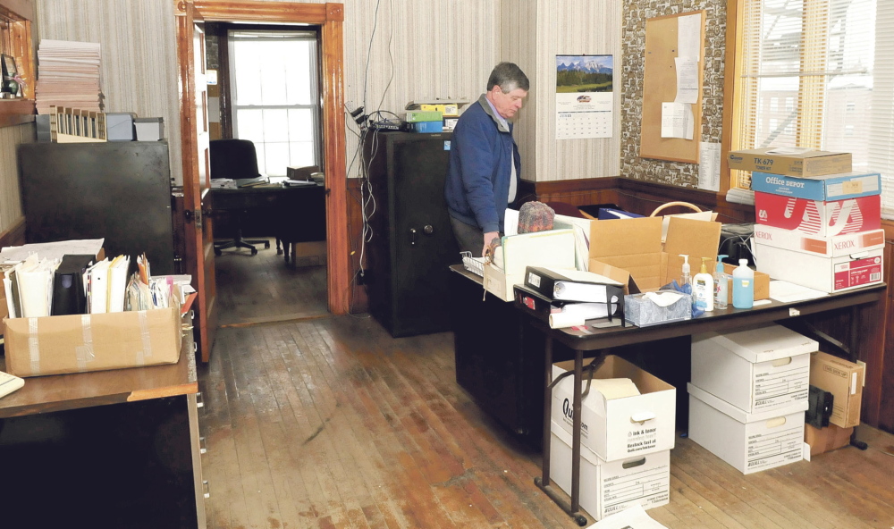 DILEMMA: Robert Worthley, Anson’s administrative assistant, looks over office materials Tuesday inside the Town Office building, which has been closed because of mold, rodent infestation and sewer gas problems. Later Tuesday, a meeting was held to discuss options for a new office building after voters at town meeting rejected money to fix the old one.