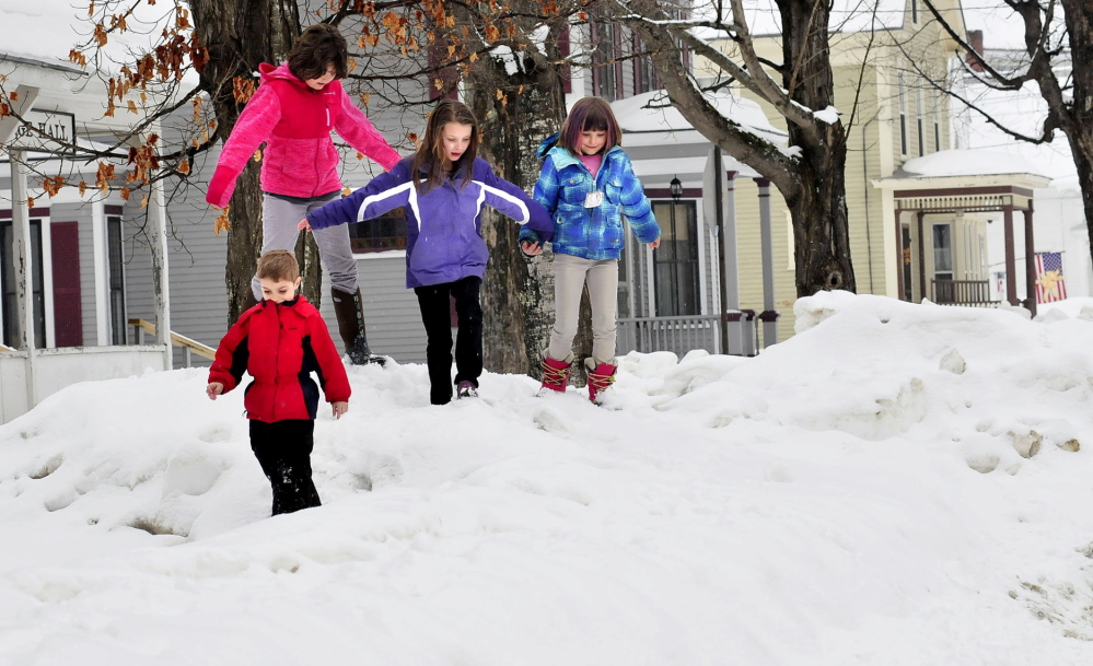 RISING BANKS: Children try to stay on top of tall snowbanks Tuesday in Bingham. From left are Peyton Plourde, front, Logan McDonald, Jordan Plourde and Lucy McDonald. More than a foot of new snow is expected in the area by Thursday.