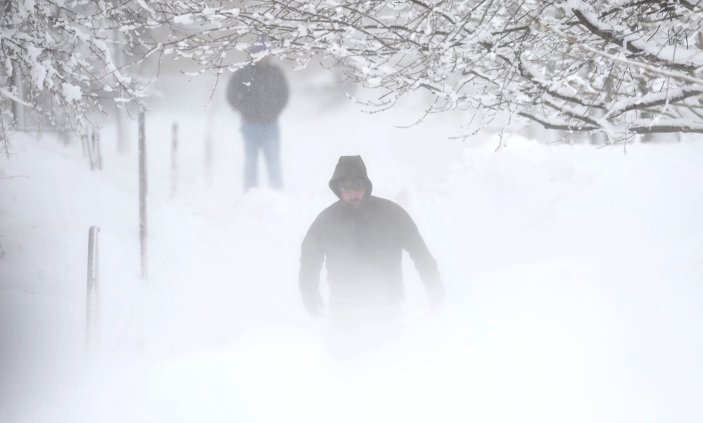 winter mist: Matt Earley clears the walkways at Colby College after a major winter storm rolled through central Maine on Thursday.