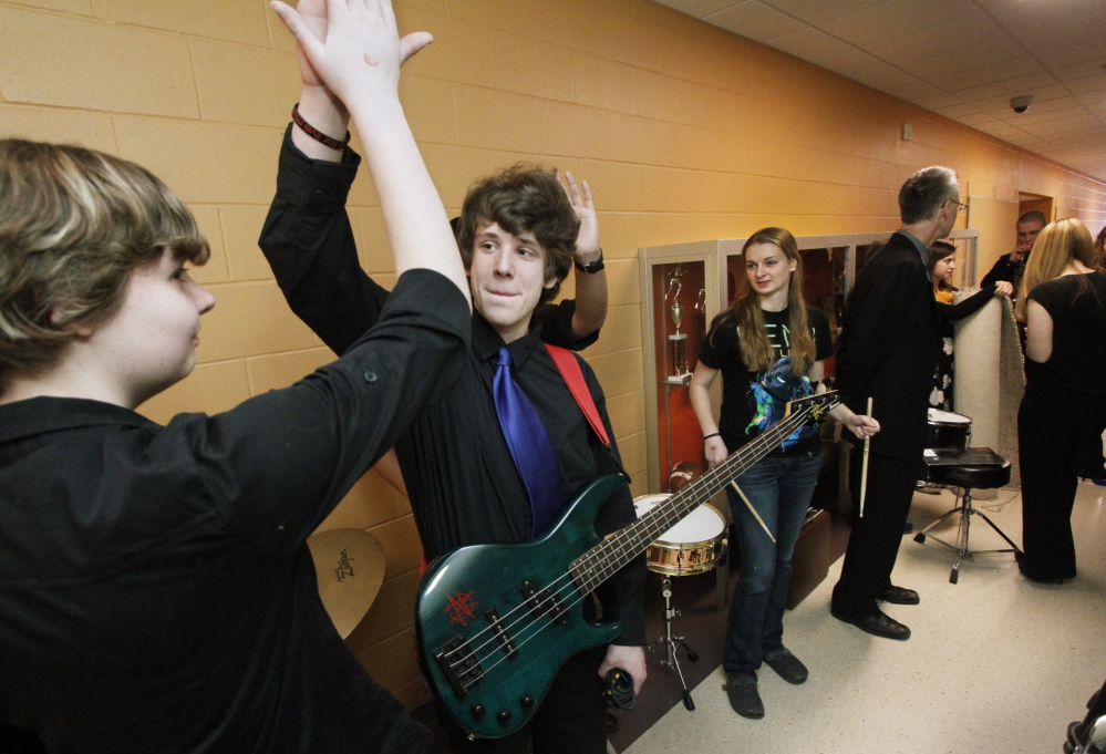 Westbrook High School jazz band members Sydney Marchand-Sirois and Milo Brooking high-five backstage before going out to compete at Hampden Academy.