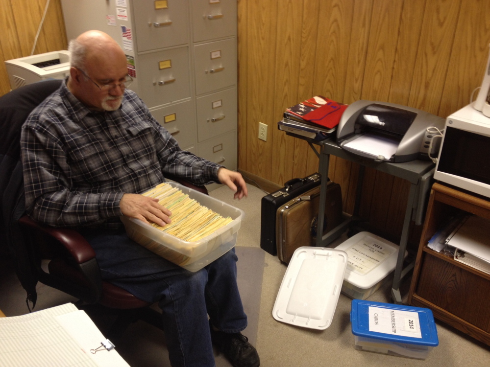 LEGION: Carl Paradis, adjutant of the Bourque-Lanigan American Legion Post, looks through a box of membership information about the Waterville veterans group. Paradis said the post, which is the largest in the state, has lost about 40 members a year and is down to 761 members.