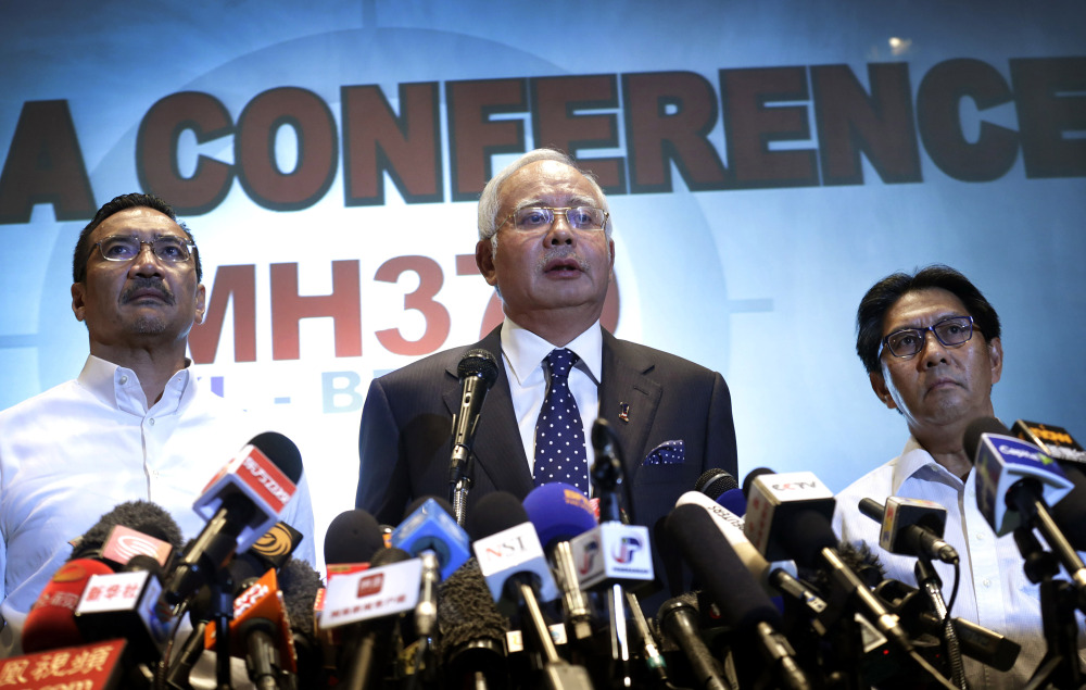 Malaysian Prime Minister Najib Razak, center, says investigators believe the missing Malaysian airliner’s communications were deliberately disabled, that it turned back from its flight to Beijing, and that it flew for more than seven hours.