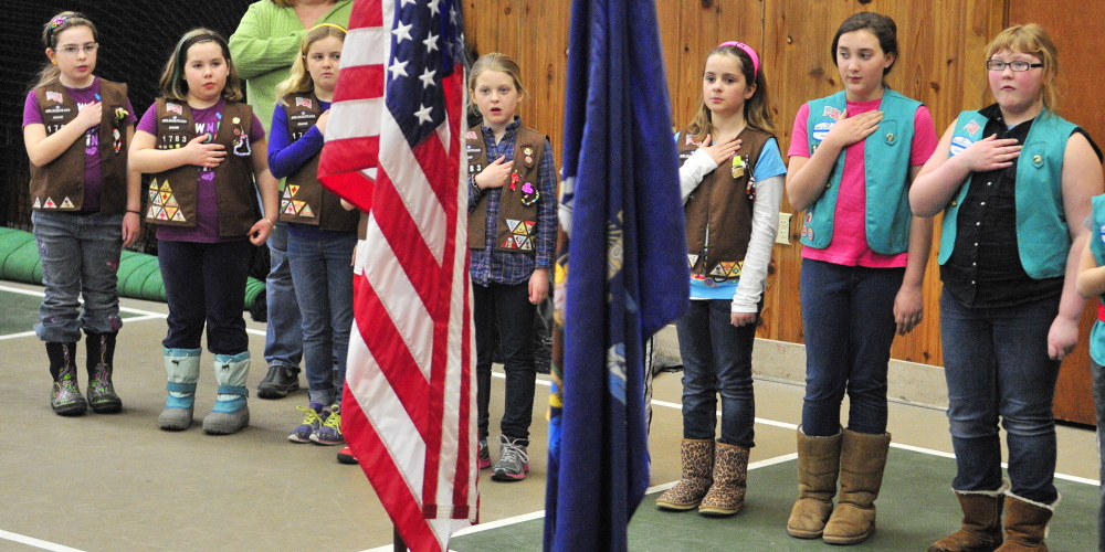 Good deeds of the day: After presenting the colors, members of Brownie Troop 1783 and Girl Scout Troop 1085 lead the Pledge of Allegiance Saturday at the start of the 2014 Belgrade Town Meeting at the Center For All Seasons. The girls also ran a concession stand and helped at the meeting by taking microphones to people speaking from the floor.