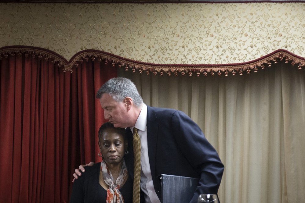 New York City Mayor Bill de Blasio, right, hugs his wife Chirlane McCray after speaking at the Church of God of Third Avenue as the congregation welcomed members of the Spanish Christian Church after the church was destroyed by Wednesday’s explosion in the East Harlem neighborhood of New York, Sunday.