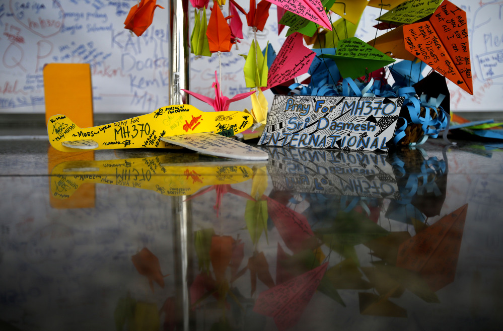 A foam plane with messages and other cards with personalized messages dedicated to people involved with the missing Malaysia Airlines jetliner MH370, is placed at the viewing gallery at Kuala Lumpur International Airport on Saturday in Sepang, Malaysia.