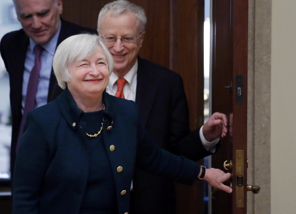 In this Monday, Feb. 3, 2014, file photo, Janet Yellen, followed by her husband, Nobel Prize winning economist George Akerlof, smiles as she walks into a room of applause by staff members before she is administered the oath of office as Federal Reserve Board chair, at the Federal Reserve in Washington.