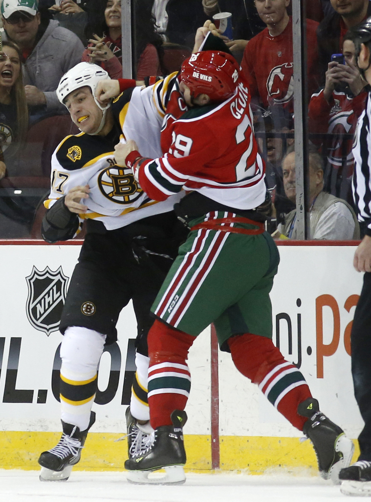Boston Bruins left wing Milan Lucic, left, and New Jersey Devils left wing Ryane Clowe fight during the first period of an NHL hockey game, Tuesday, March 18, 2014, in Newark, N.J.