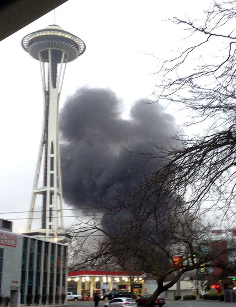 In this photo provided by KIRO- TV, smoke rises at the scene of a helicopter crash outside the KOMO-TV studios near the space needle in Seattle.