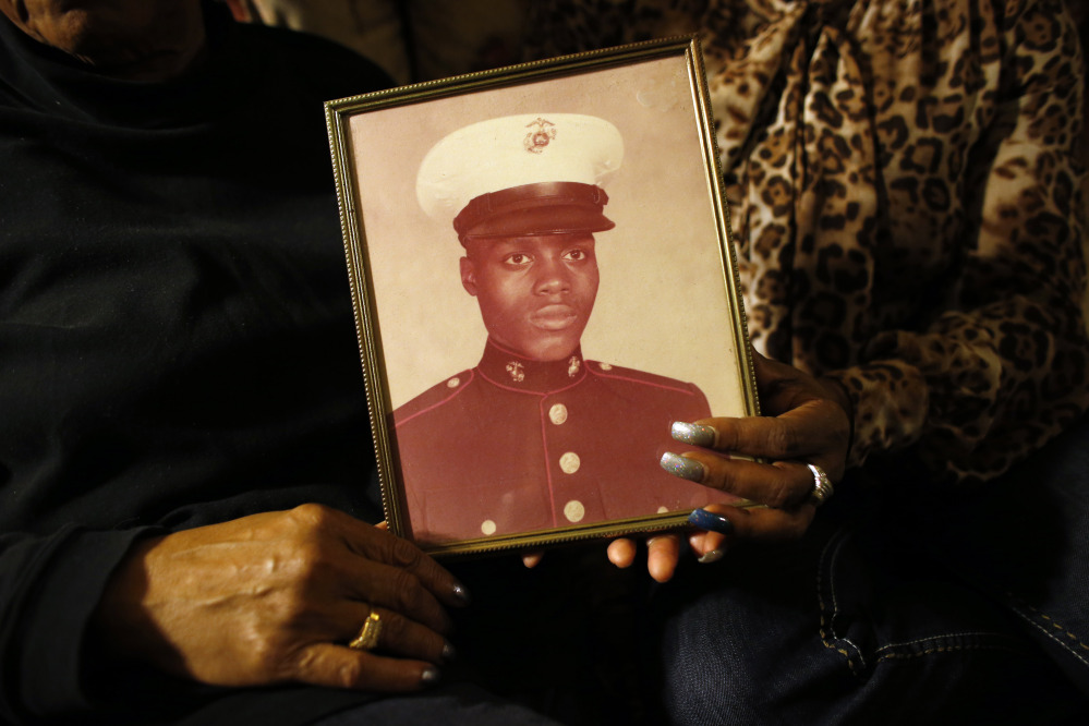 In this March 12, 2014 photo, a picture of Jerome Murdough is held by his mother Alma Murdough left, and sister Cheryl Warner at Alma Murdough’s home in the Queens borough of New York.
