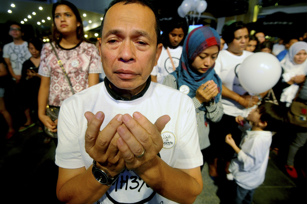 A Malaysian Muslim man prays during an interfaith event for the missing Malaysia Airlines flight MH370 at a shopping mall in Petaling Jaya outside Kuala Lumpur, Malaysia, on Tuesday.