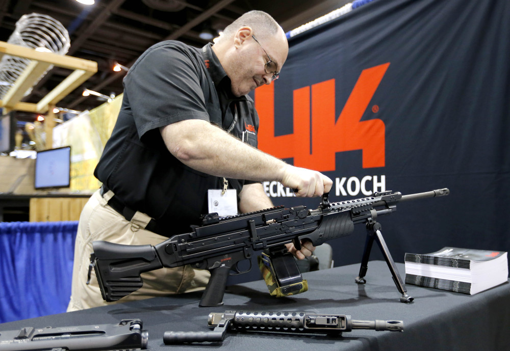Barry Witt, of Heckler & Koch arms manufacturers, sets up a weapons display at the 8th annual Border Security Expo on Tuesday in Phoenix.
