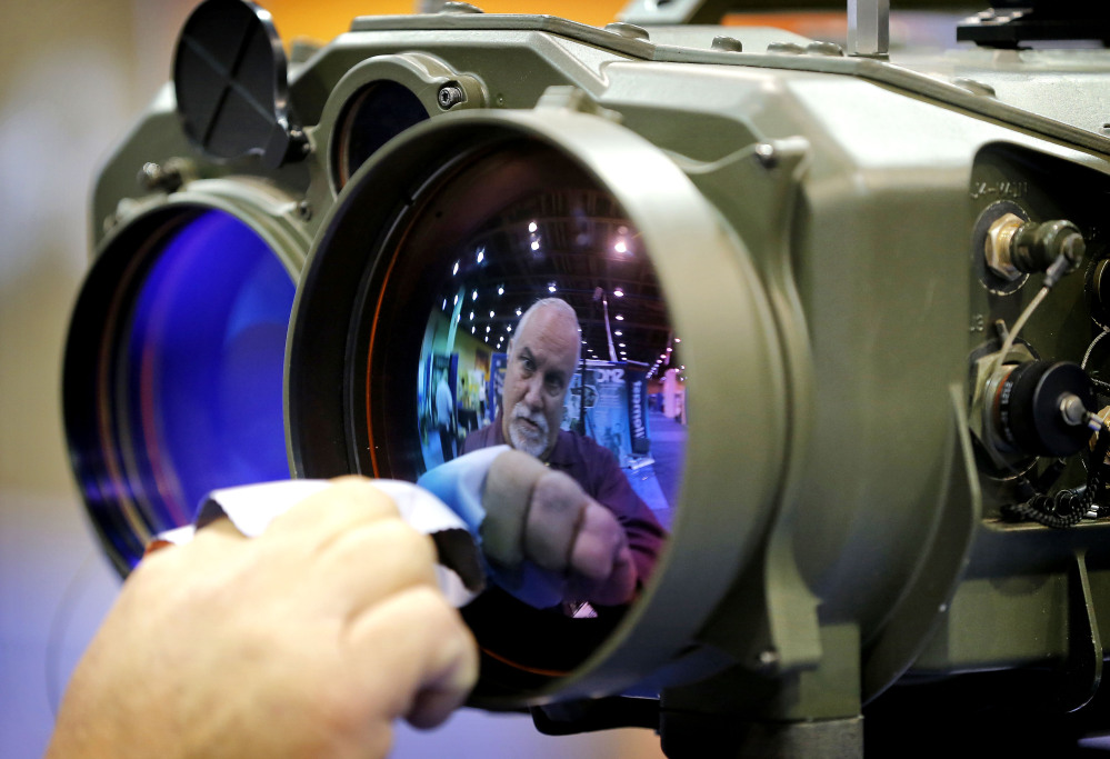 Gary Wagner, of Elbit Systems of America, cleans the lens of a long-range thermal imaging targeting system at the Border Security Expo.