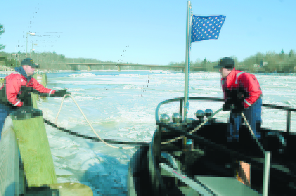 breaking the ice: Coast Guard cutter Bridle crew members Kyle Shute, left, and Steven Boyd untie their vessel from a bulkhead in Gardiner in this 2010 file photo.