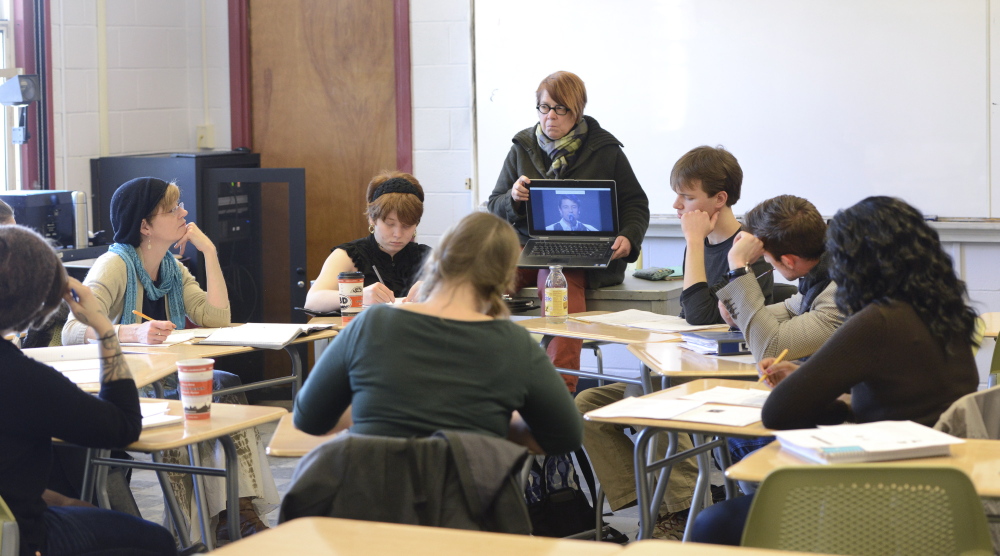Professor Nancy Erickson plays a video during her French music class at USM in Portland. Faculty members say small classes allow for certain teaching methods, such as assigning papers, that can’t be employed effectively in bigger classes.