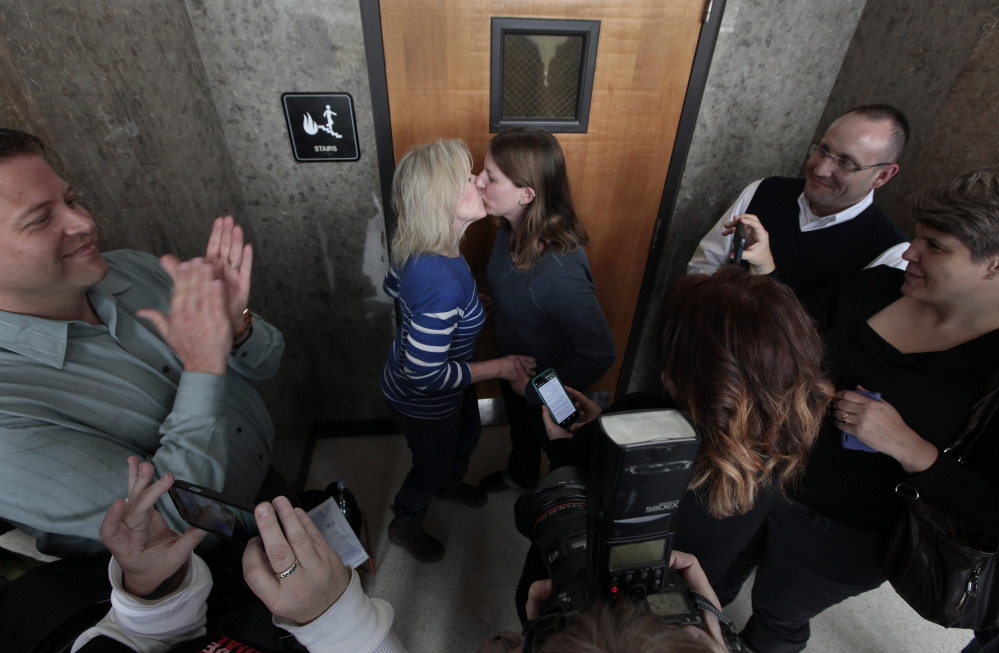 Elizabeth Gardiner, left, and Stephanie Citron kiss after being married in a hallway at the Oakland County Clerk in Pontiac, Mich., Saturday.